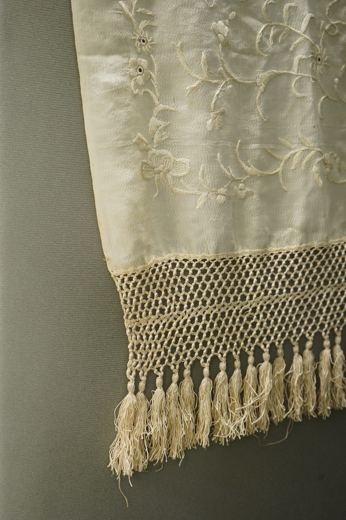 An early 20th century Chinese cream on cream silk embroidered, fringed stole, 65cm wide. Condition - some light staining.